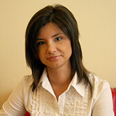 Наталія Тихонченко після консультації лікаря-офтальмолога сидить у червоному кріслі